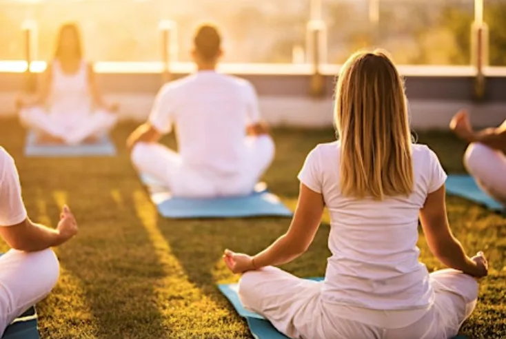 Group yoga session outdoors at sunrise