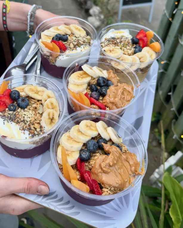 Acai bowls topped with banana, berries, and granola