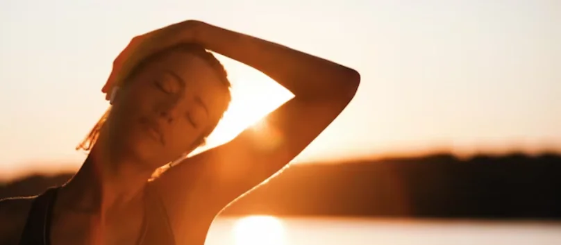 Stretching by the water at sunset after a session