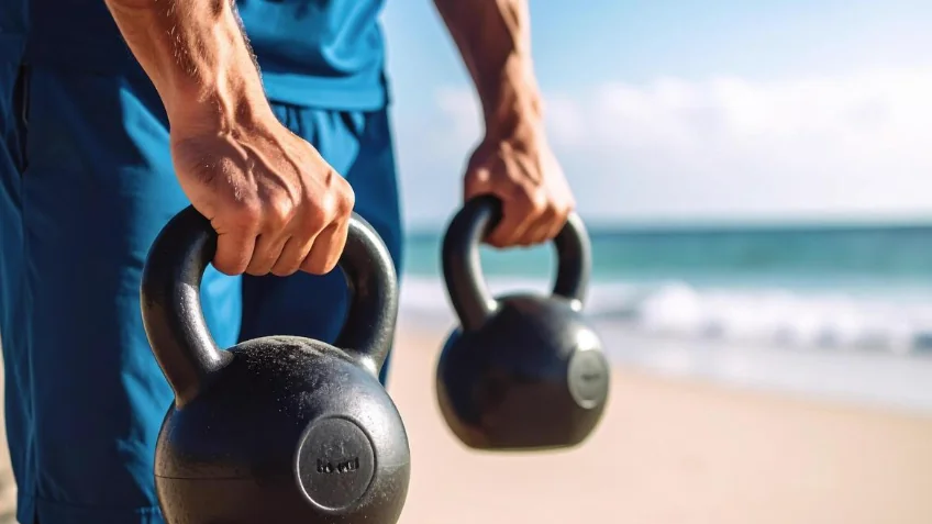 Carrying kettlebells along the beach