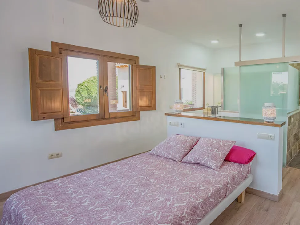 Bedroom with double bed and shuttered window