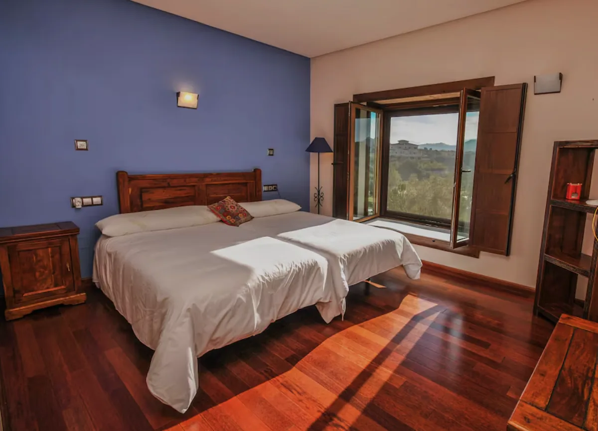 Villa bedroom with wooden floors and countryside view