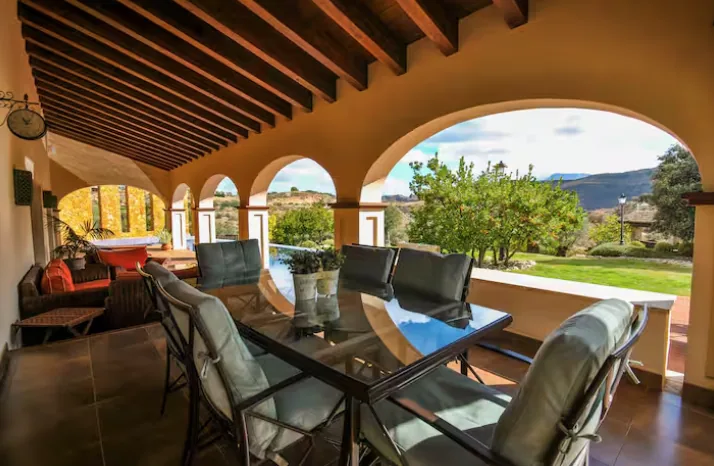 Covered terrace with dining table and countryside view